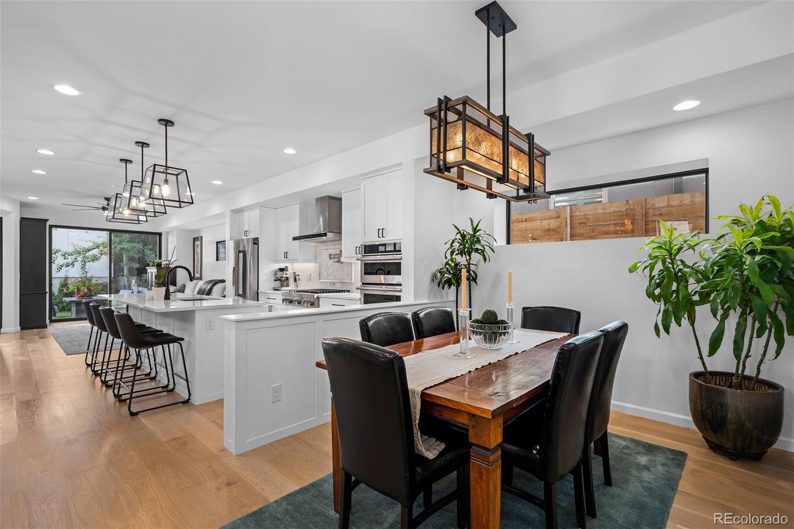 3451 Quivas Street Denver, CO 80211 - Photo 5 of 50 a dining room with wooden floor a chandelier a glass table and chairs