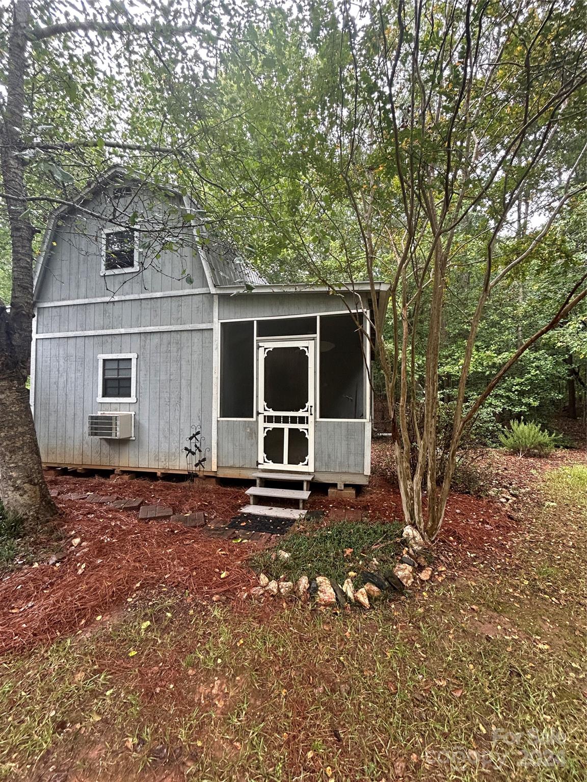993 West Shiloh Unity Road Lancaster, SC 29720 - Photo 19 of 26 a backyard of a house with barbeque oven and trees