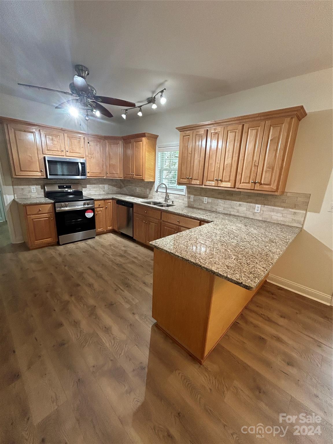 993 West Shiloh Unity Road Lancaster, SC 29720 - Photo 5 of 26 a large kitchen with kitchen island a sink dishwasher a stove and a refrigerator with wooden floor
