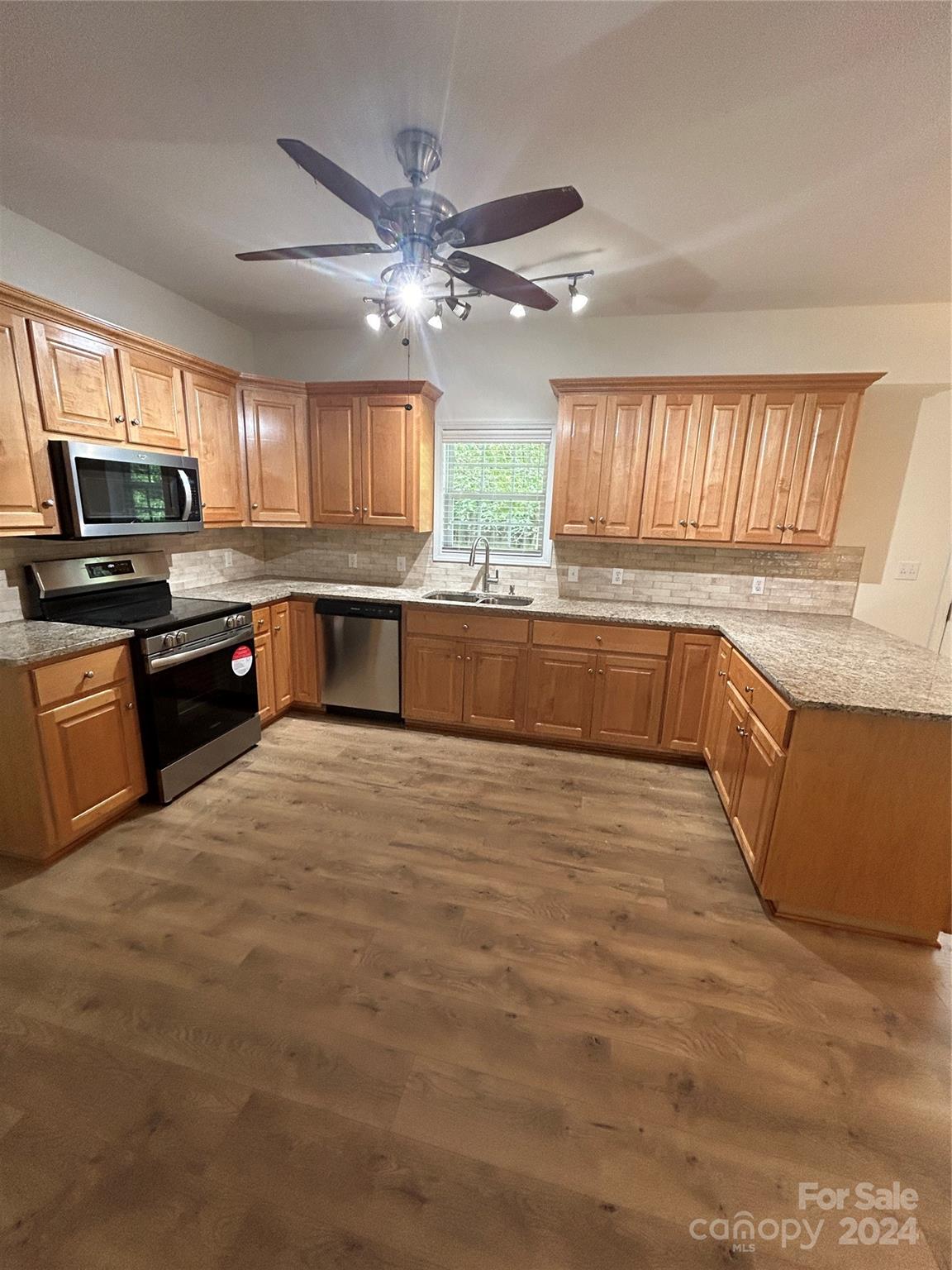 993 West Shiloh Unity Road Lancaster, SC 29720 - Photo 7 of 26 a large kitchen with kitchen island granite countertop a stove top oven a sink a counter space and cabinets
