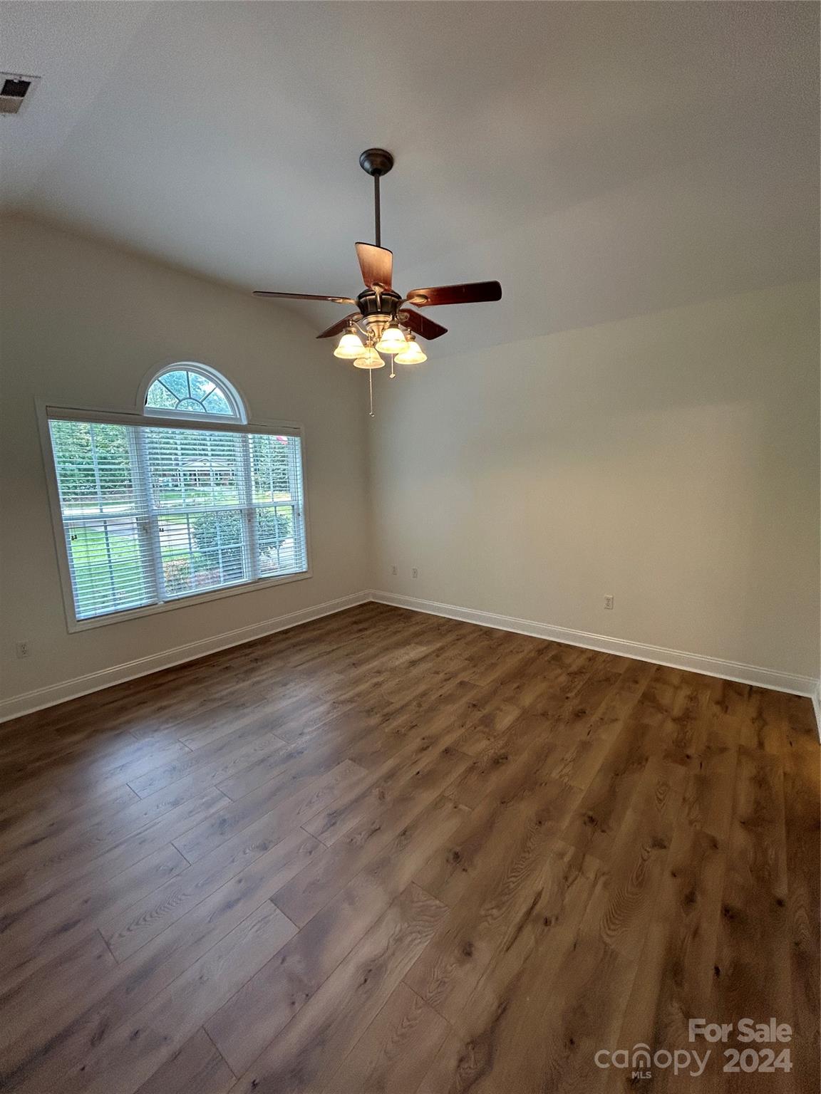 993 West Shiloh Unity Road Lancaster, SC 29720 - Photo 10 of 26 an empty room with wooden floor chandelier fan and windows