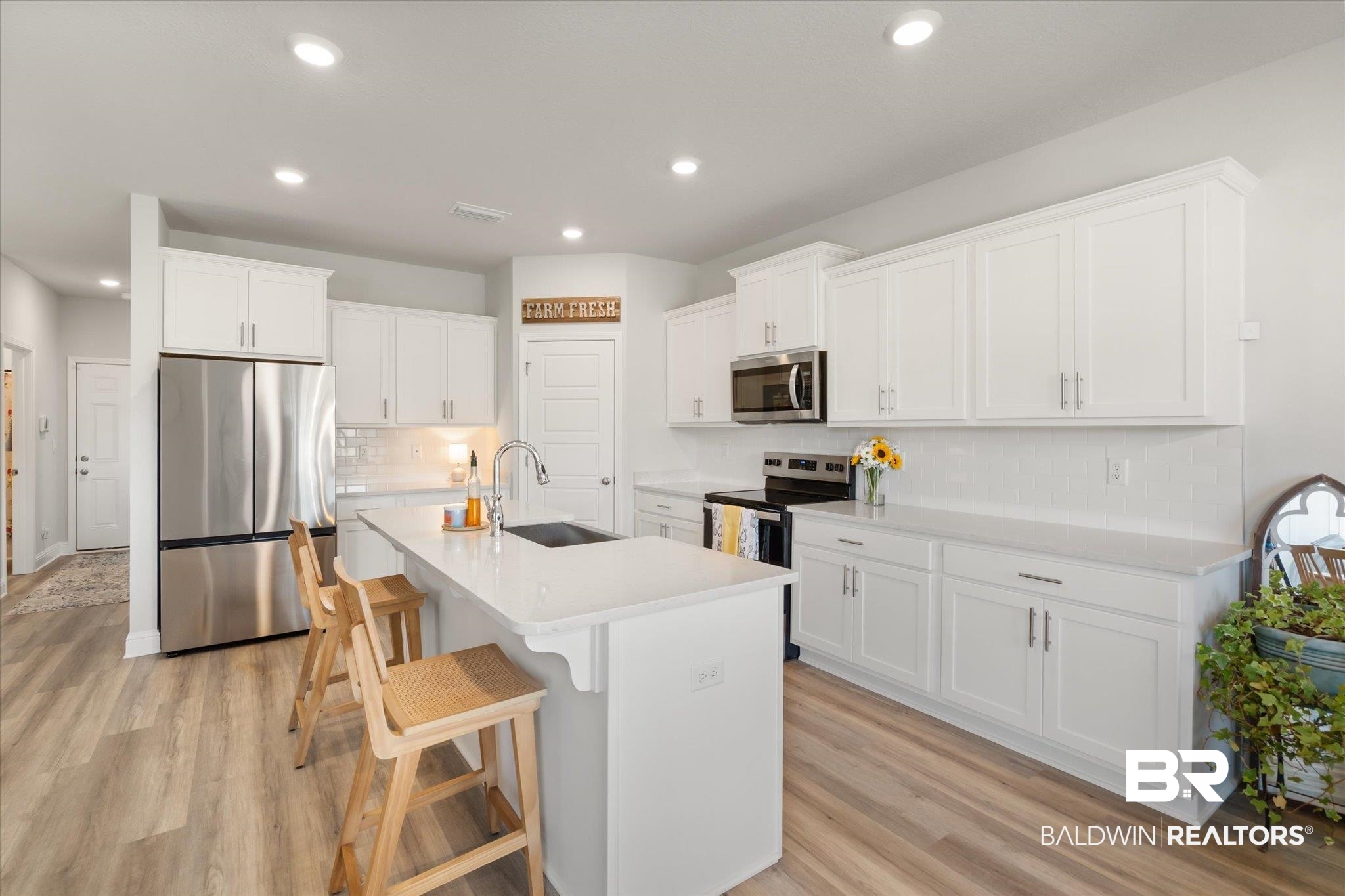 1167 Provision Road Mobile, AL 36608 - Photo 6 of 20 Kitchen featuring a sink, light countertops, light wood-style floors, stainless steel appliances, and a kitchen island with sink