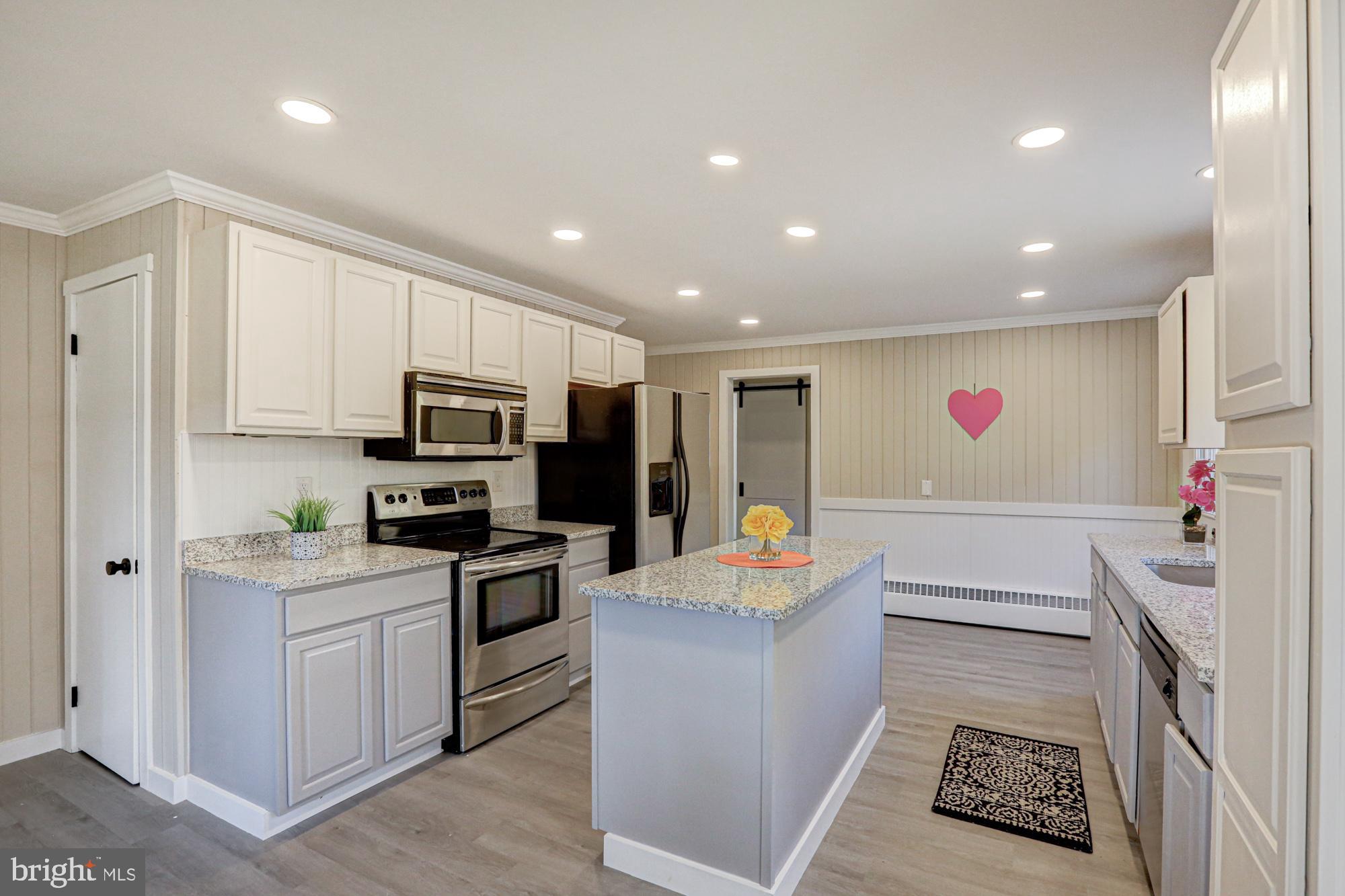 4841 Sandtown Road Felton, DE 19943 - Photo 19 of 70 a kitchen with white cabinets and stainless steel appliances
