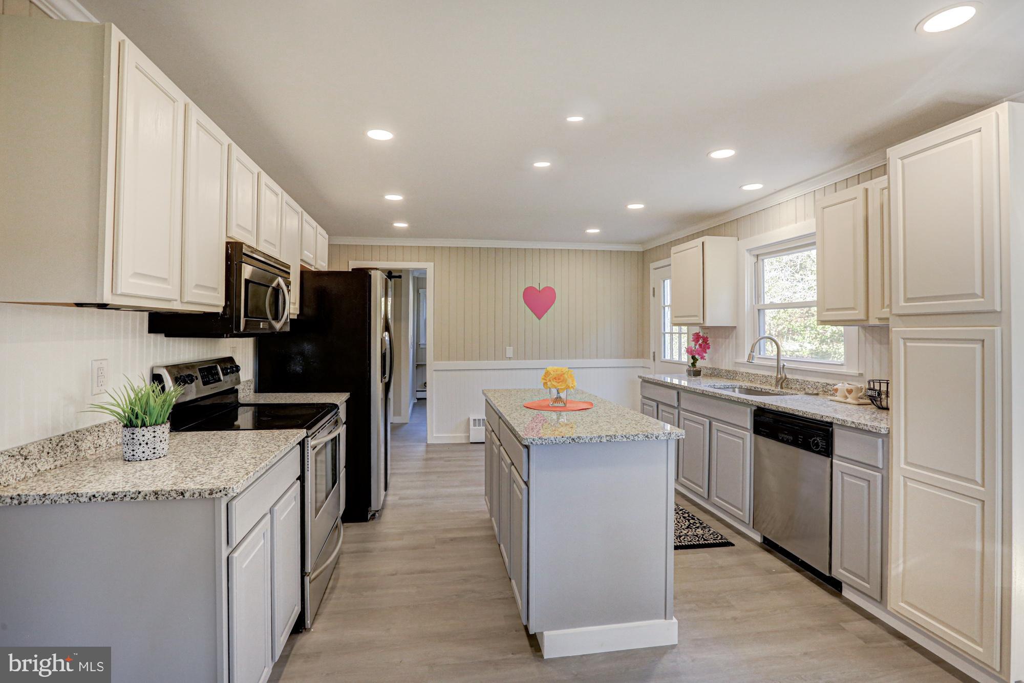 4841 Sandtown Road Felton, DE 19943 - Photo 20 of 70 a kitchen with stainless steel appliances granite countertop a stove top oven a refrigerator a sink and dishwasher with white cabinets
