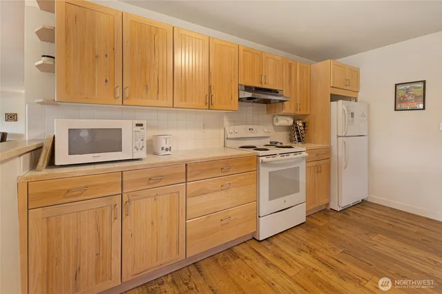 a view of a kitchen with kitchen island a sink and a stove