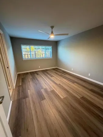 a view of an empty room and window and wooden floor