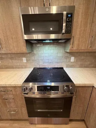 a stove top oven sitting inside of a kitchen