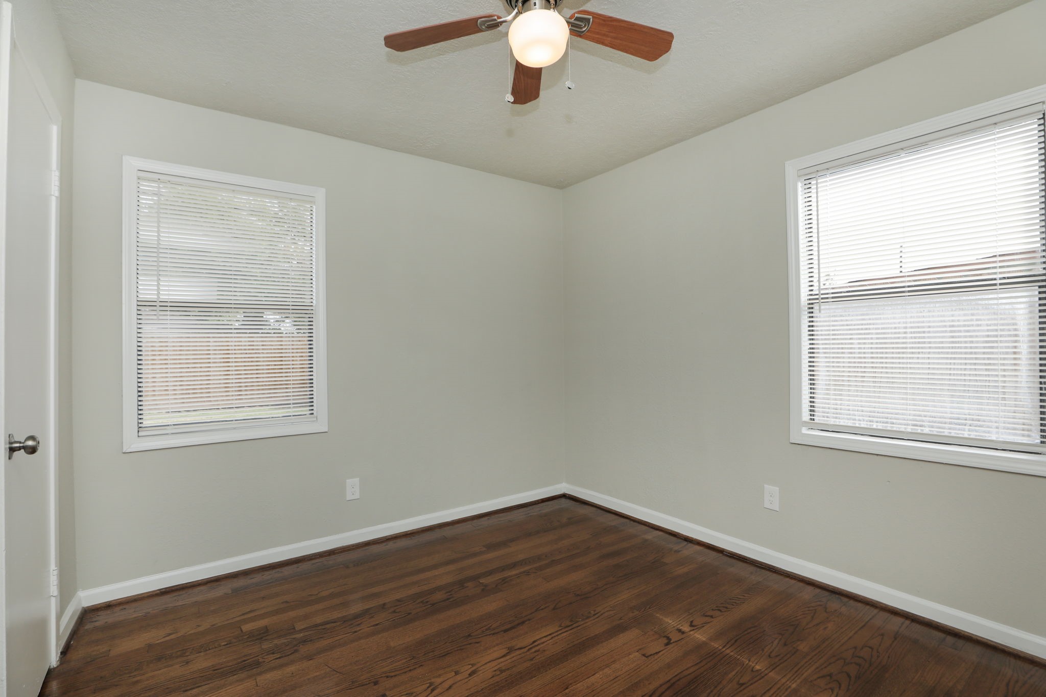 718 Champs Street Channelview, TX 77530 - Photo 21 of 31 an empty room with wooden floor chandelier fan and windows