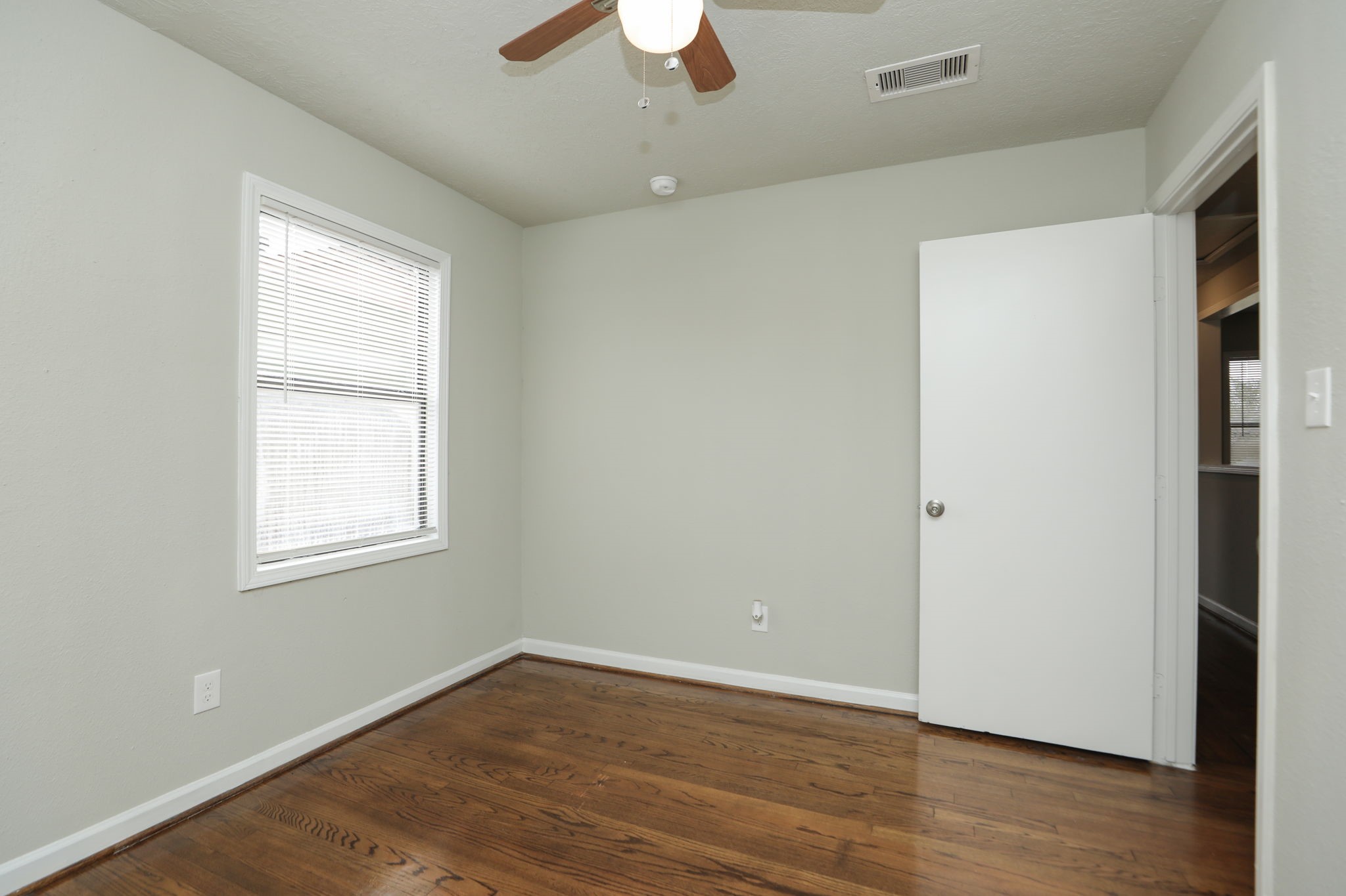 718 Champs Street Channelview, TX 77530 - Photo 22 of 31 a view of an empty room with wooden floor and a window