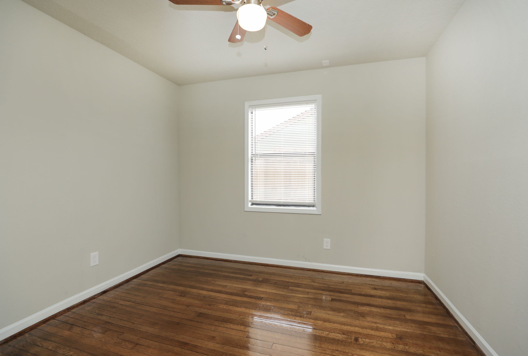 718 Champs Street Channelview, TX 77530 - Photo 23 of 31 an empty room with wooden floor chandelier fan and window