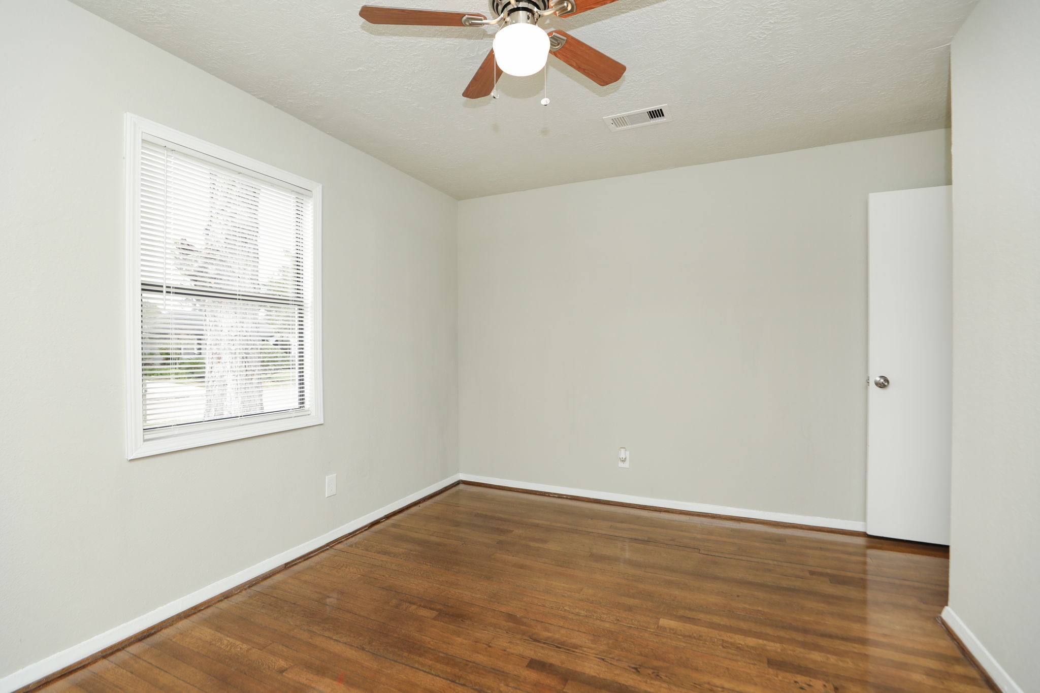 718 Champs Street Channelview, TX 77530 - Photo 25 of 31 an empty room with wooden floor chandelier fan and windows