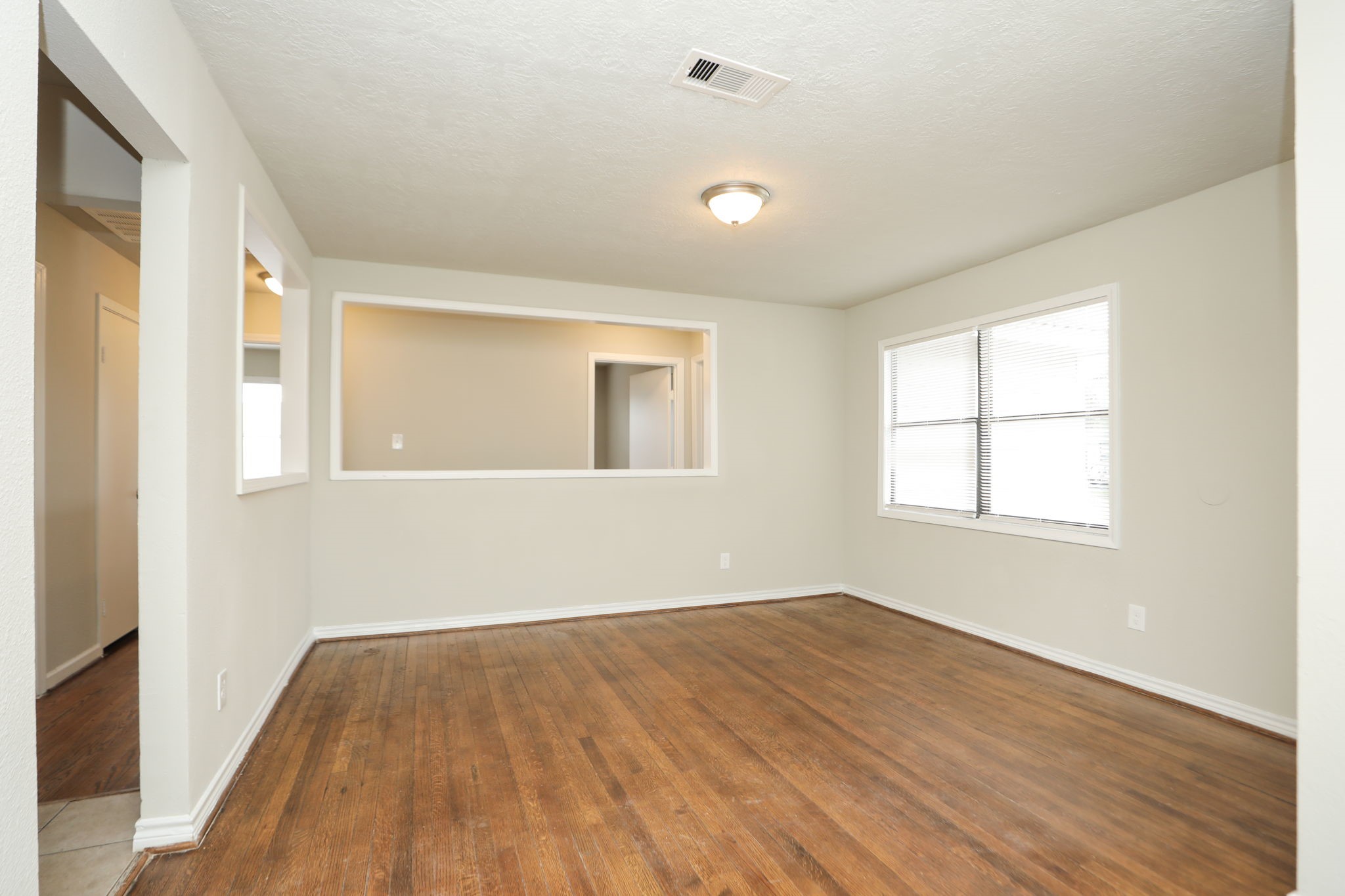 718 Champs Street Channelview, TX 77530 - Photo 5 of 31 an empty room with wooden floor and windows