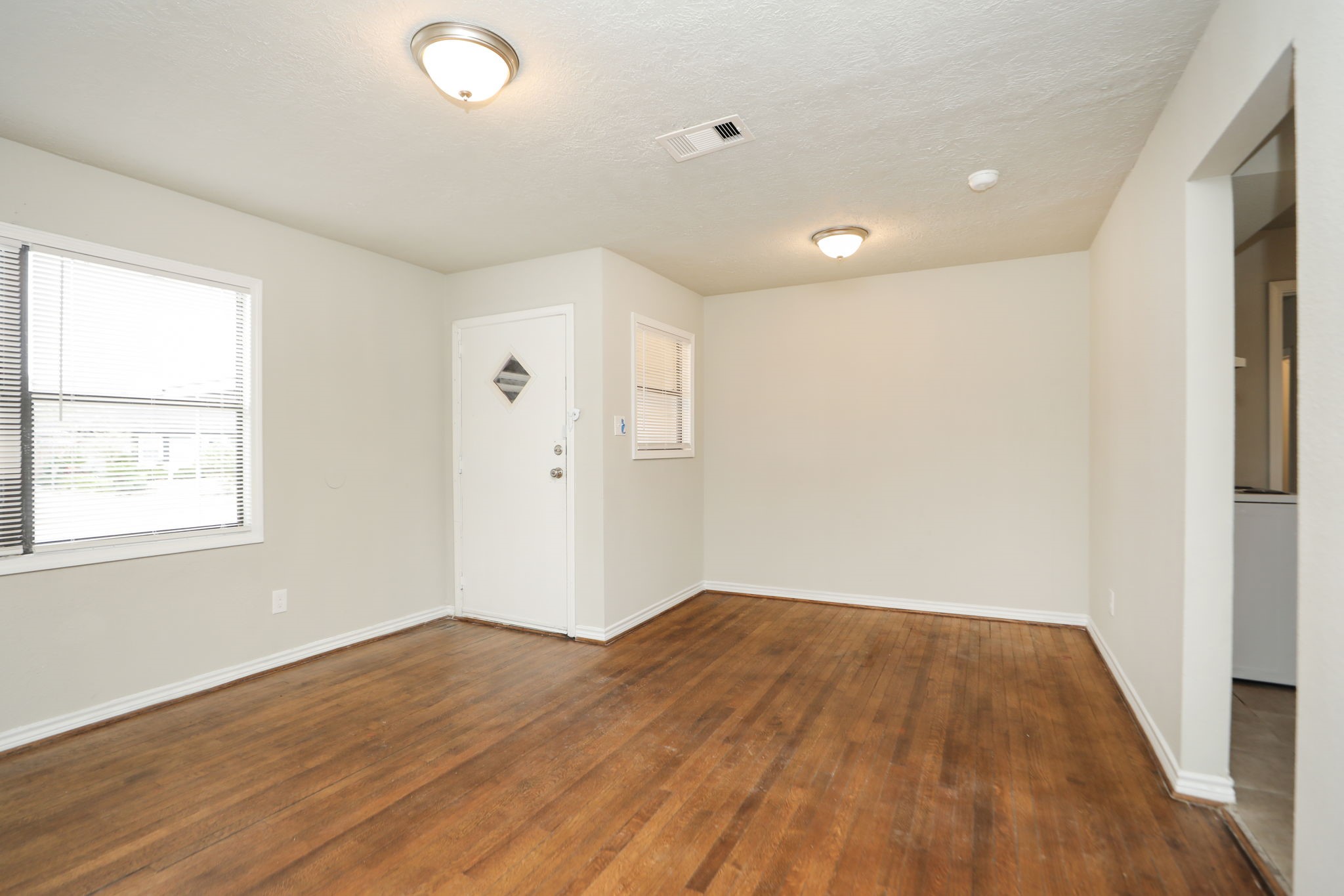 718 Champs Street Channelview, TX 77530 - Photo 6 of 31 an empty room with wooden floor and windows