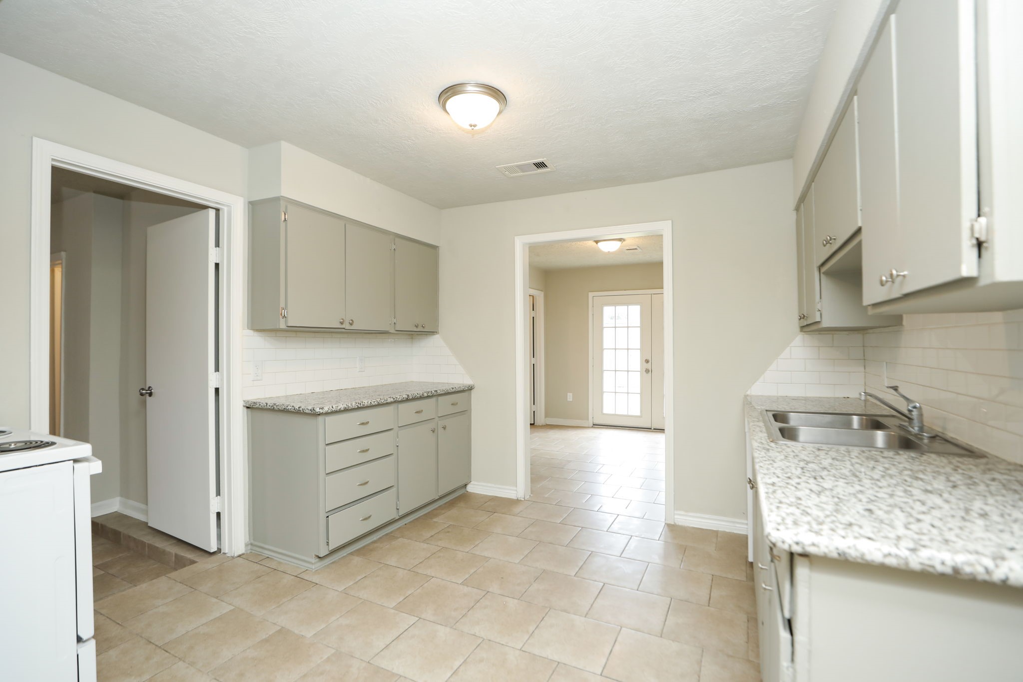 718 Champs Street Channelview, TX 77530 - Photo 7 of 31 a kitchen with a sink stove and cabinets