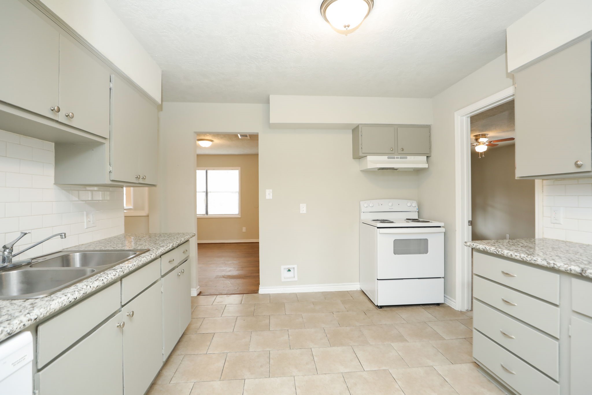 718 Champs Street Channelview, TX 77530 - Photo 10 of 31 a kitchen with granite countertop white cabinets and white appliances