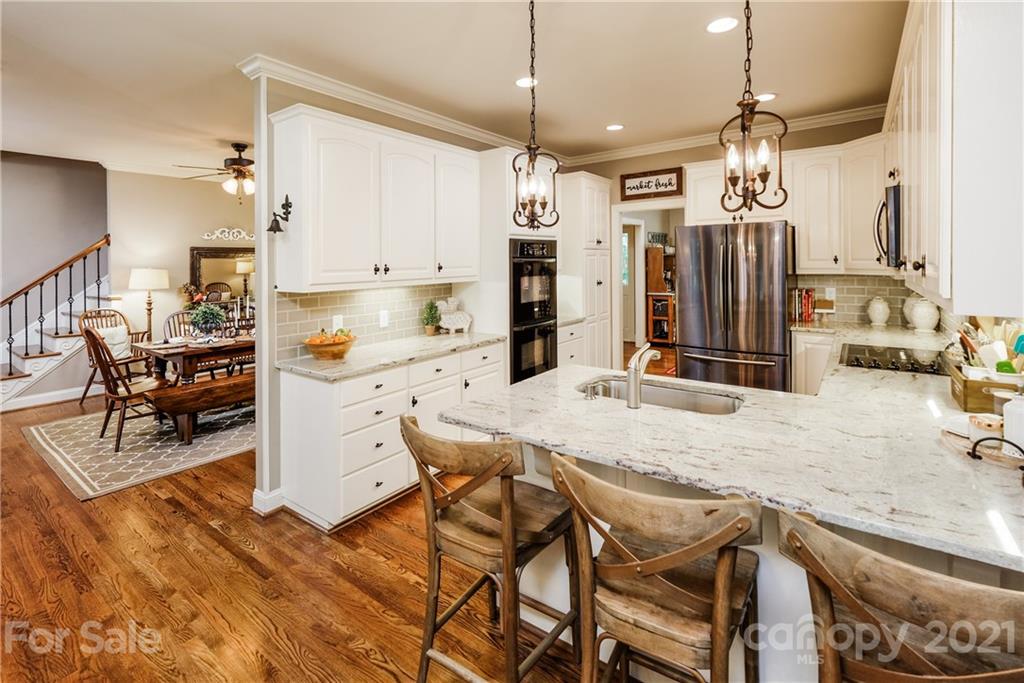 1172 Ben Black Road Midland, NC 28107 - Photo 11 of 48 a kitchen with stainless steel appliances kitchen island granite countertop a table chairs and a refrigerator