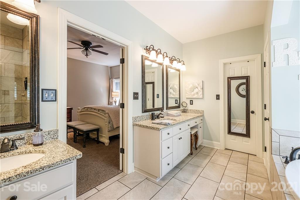 1172 Ben Black Road Midland, NC 28107 - Photo 21 of 48 a en suite bathroom with a granite countertop double vanity sink a mirror and a shower