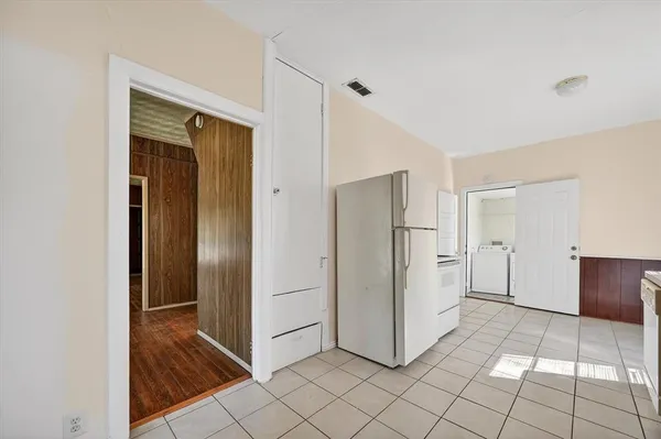 a view of a refrigerator in kitchen and white cabinets