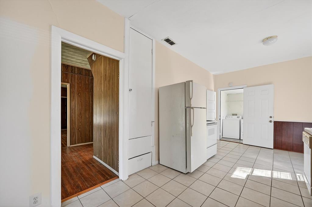 800 South Jefferson Street Pilot Point, TX 76258 - Photo 12 of 27 a view of a refrigerator in kitchen and white cabinets