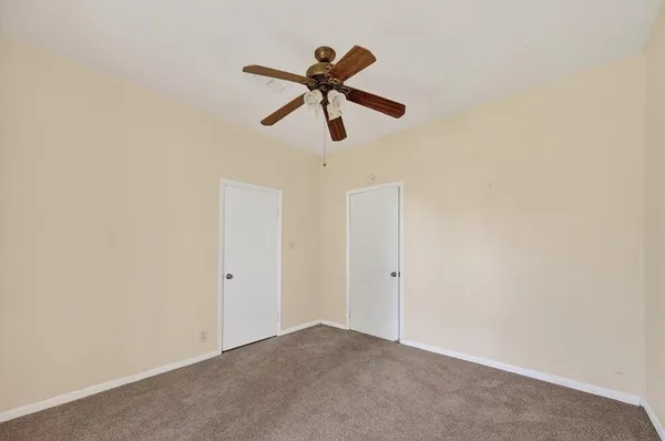 a view of empty room with wooden floor and ceiling fan