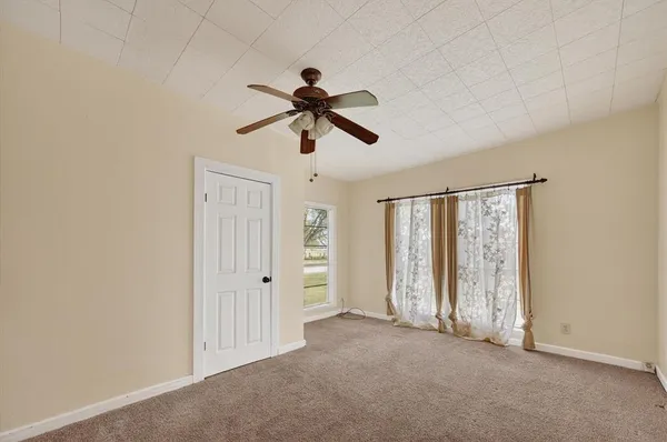 an empty room with chandelier fan