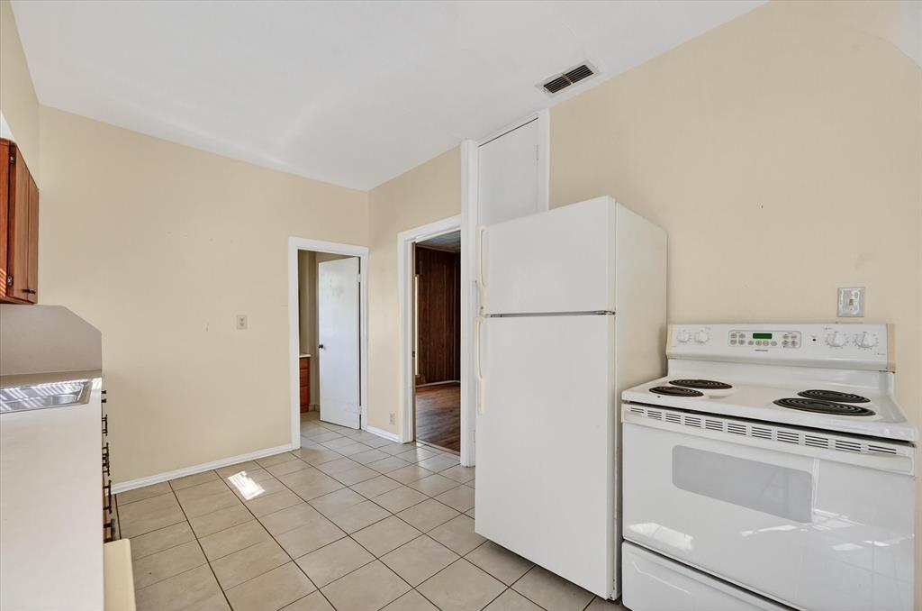 800 South Jefferson Street Pilot Point, TX 76258 - Photo 10 of 27 a kitchen with a refrigerator a stove top oven and cabinets
