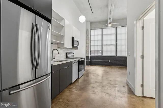 a kitchen with granite countertop a refrigerator and a sink