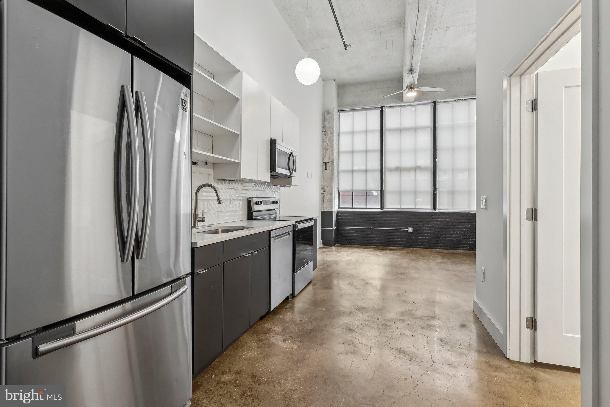 2000 North 2nd Street, Unit 404 Philadelphia, PA 19122 - Photo 4 of 9 a kitchen with granite countertop a refrigerator and a sink