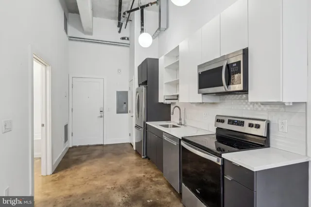 a kitchen with stainless steel appliances a stove microwave and refrigerator