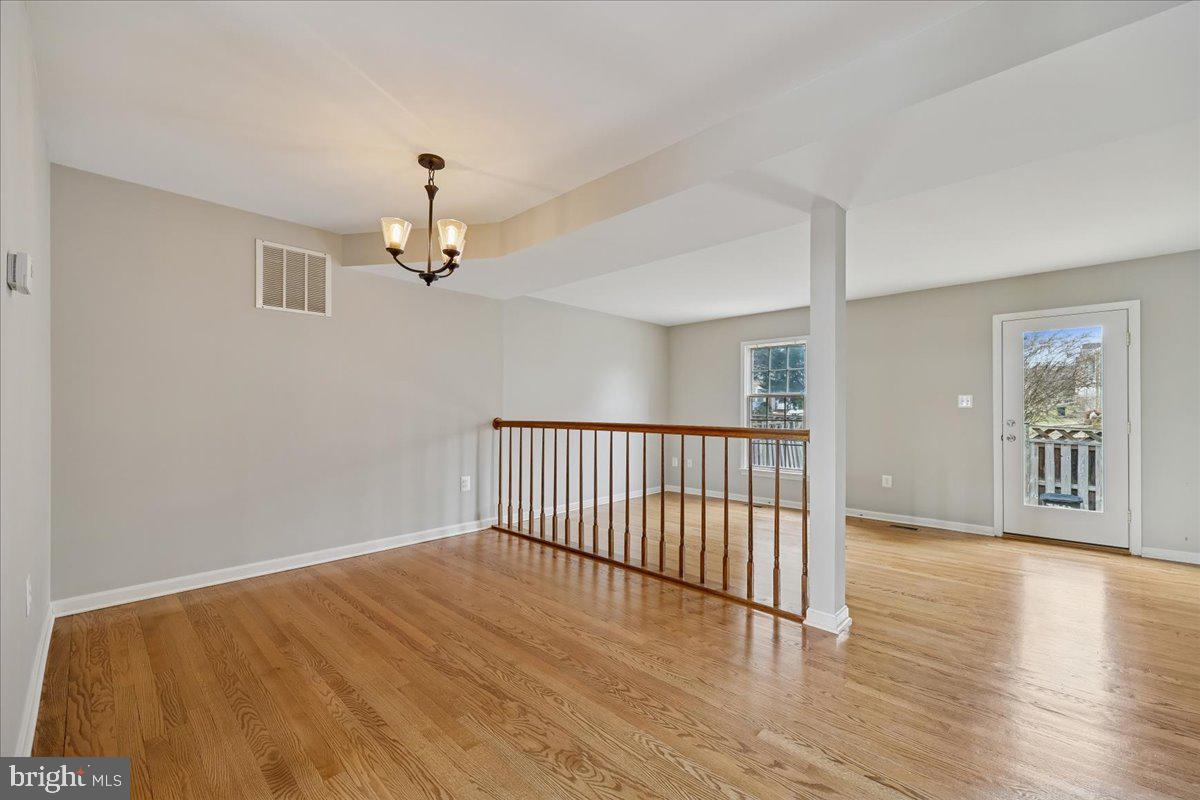 8024 Waterview Court Frederick, MD 21701 - Photo 12 of 72 a view of a hallway with wooden floor and chandelier