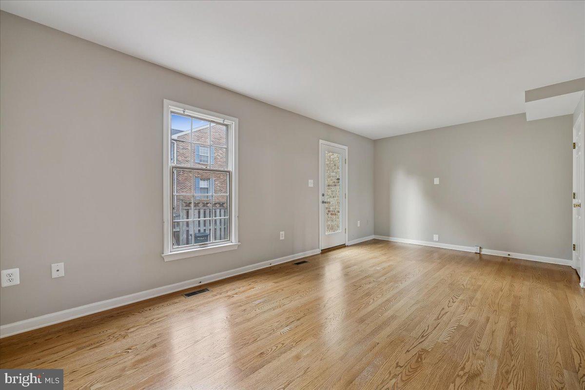 8024 Waterview Court Frederick, MD 21701 - Photo 16 of 72 an empty room with wooden floor and windows