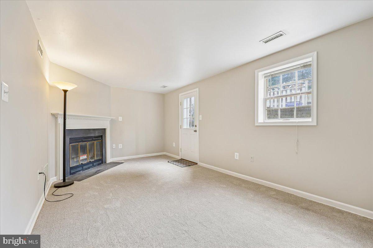 8024 Waterview Court Frederick, MD 21701 - Photo 30 of 72 an empty room with a fireplace and windows