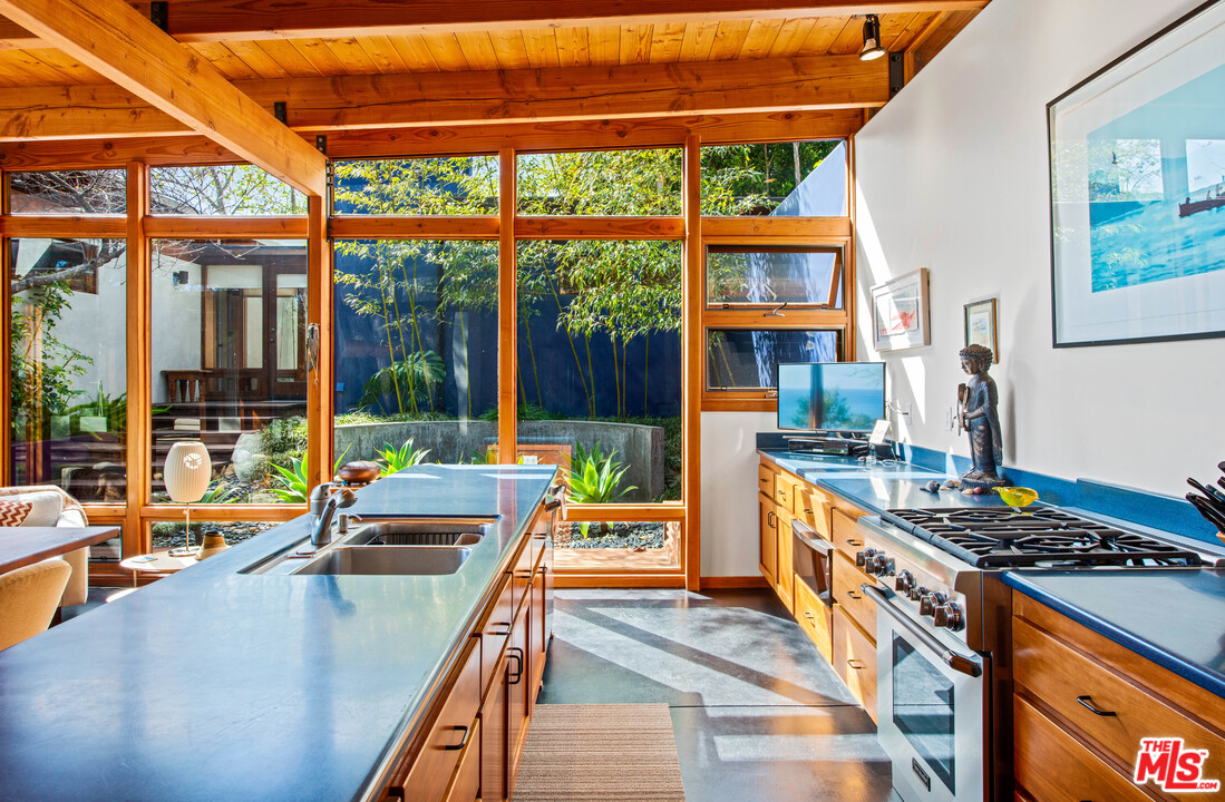 32496 Pacific Coast Highway Malibu, CA 90265 - Photo 18 of 51 a kitchen with stainless steel appliances kitchen island a large stove a sink and a large window
