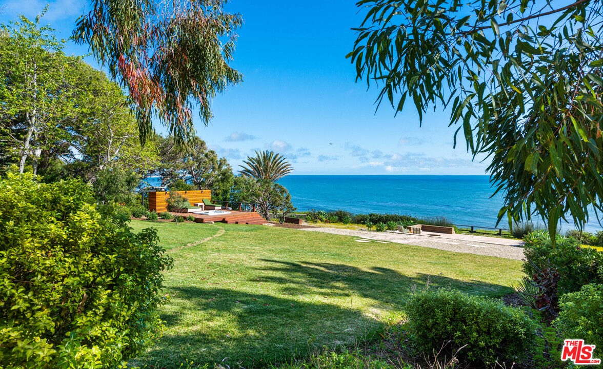 32496 Pacific Coast Highway Malibu, CA 90265 - Photo 22 of 51 a backyard of a house with table and chairs plants and large tree