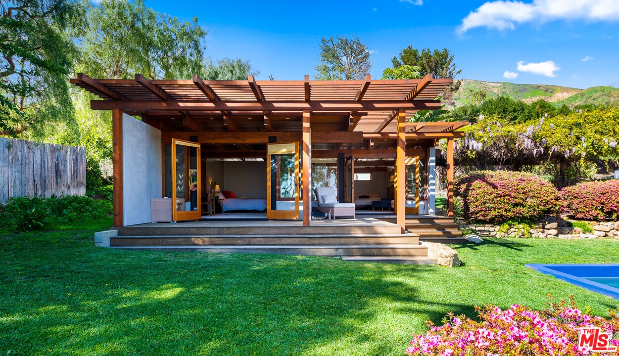 32496 Pacific Coast Highway Malibu, CA 90265 - Photo 39 of 51 a view of a chair and table in patio with a wooden fence