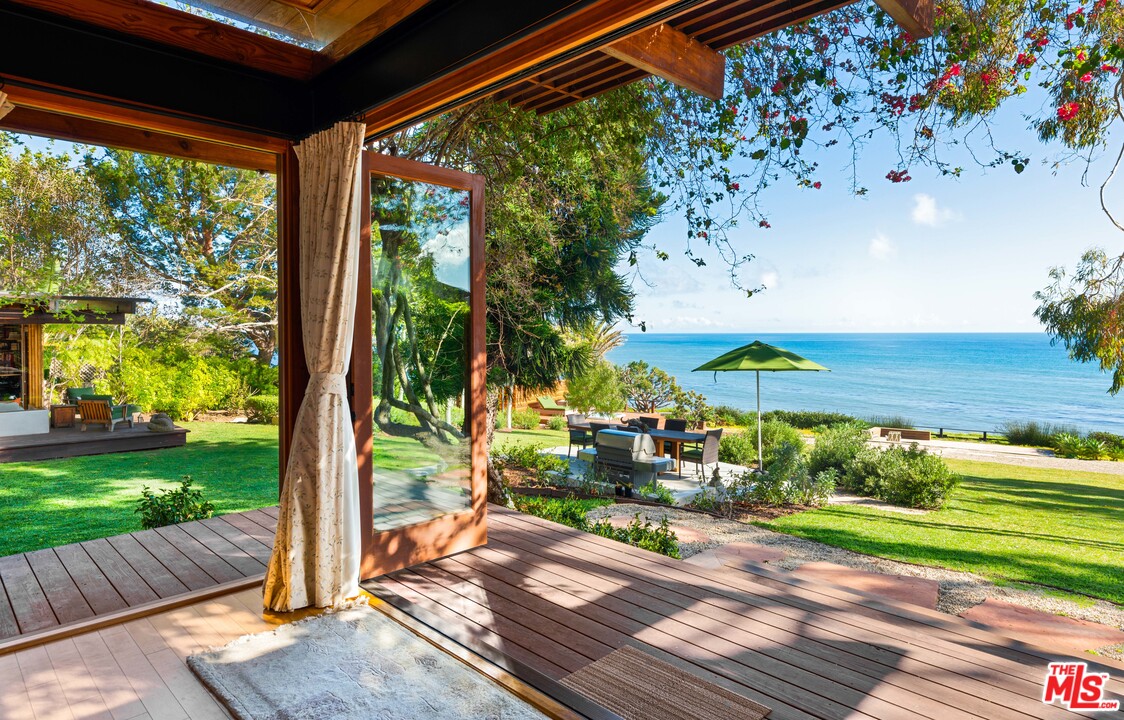 32496 Pacific Coast Highway Malibu, CA 90265 - Photo 6 of 51 a view of a patio with table and chairs potted plants with wooden floor and fence