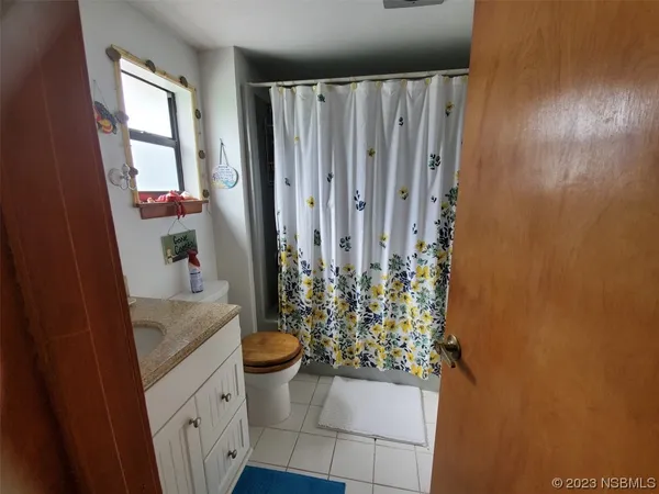 a bathroom with a granite countertop sink a toilet and shower