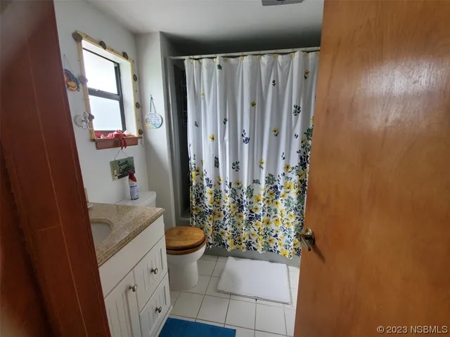 a bathroom with a granite countertop sink a toilet and shower