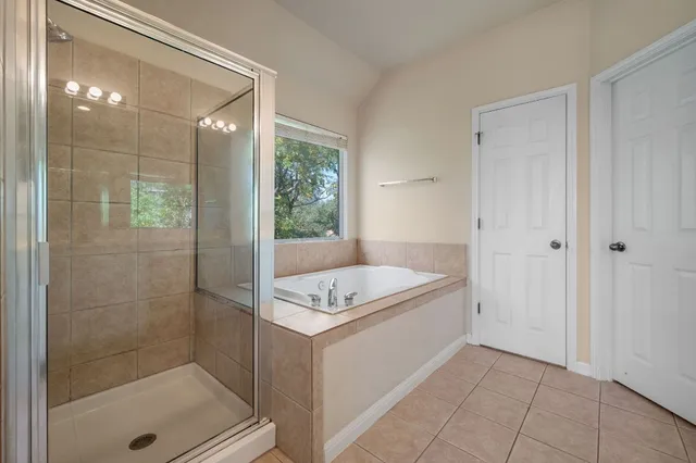 a bathroom with a tub shower and sink