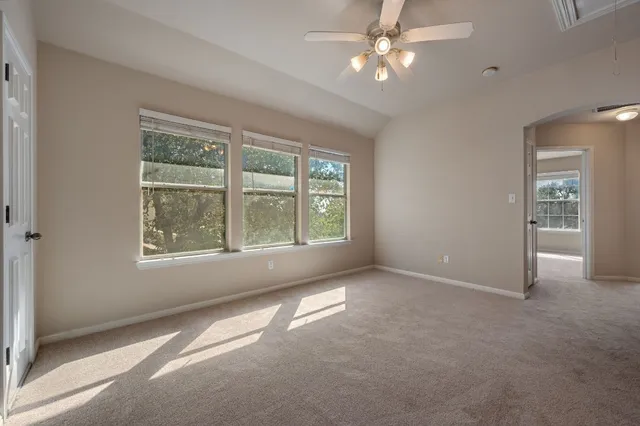 an empty room with windows and fan