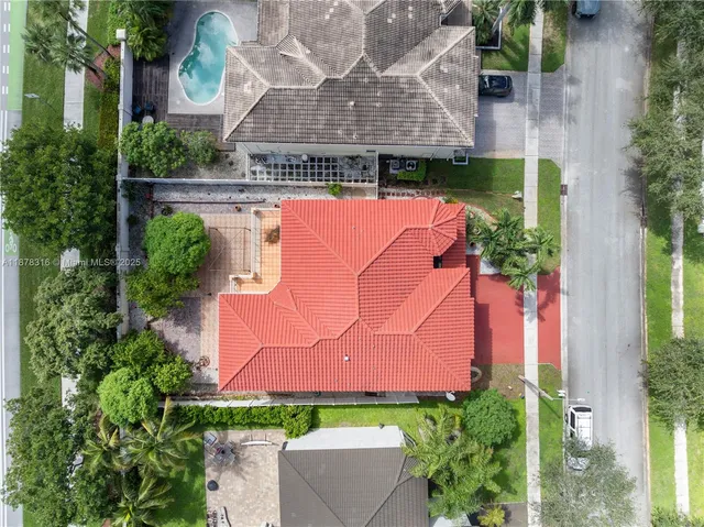 an aerial view of residential houses with outdoor space and ocean view