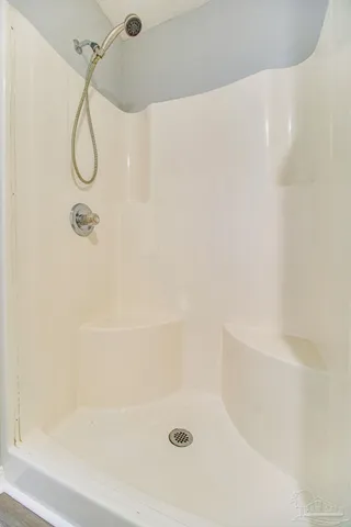 a bathroom with a bath tub with a shower