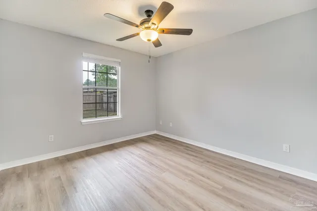 wooden floor in an empty room with a window
