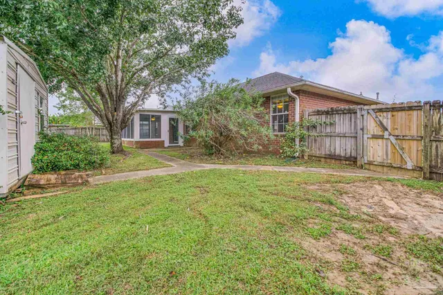 a view of a yard in front of a house with large tree