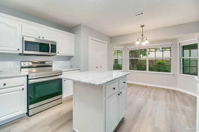 a kitchen with granite countertop a stove and a microwave oven