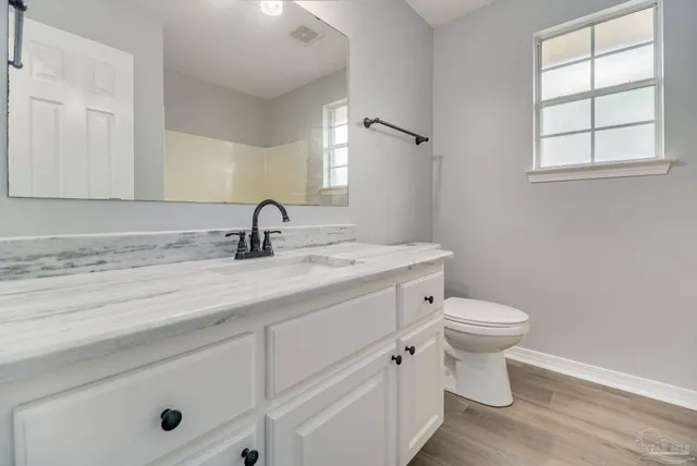 a bathroom with a toilet sink and mirror