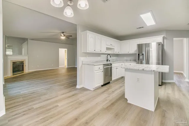 a kitchen with a sink cabinets and wooden floor