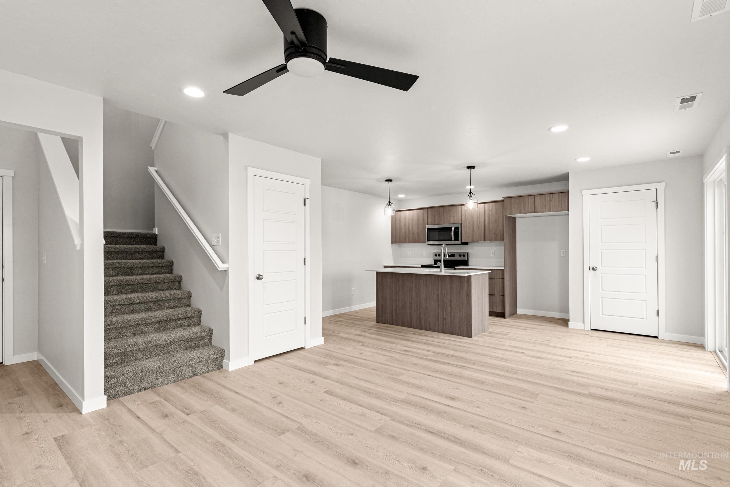 10818 Rutland Street Caldwell, ID 83605 - Photo 12 of 22 Kitchen featuring light countertops, a center island with sink, modern cabinets, pendant lighting, and ceiling fan