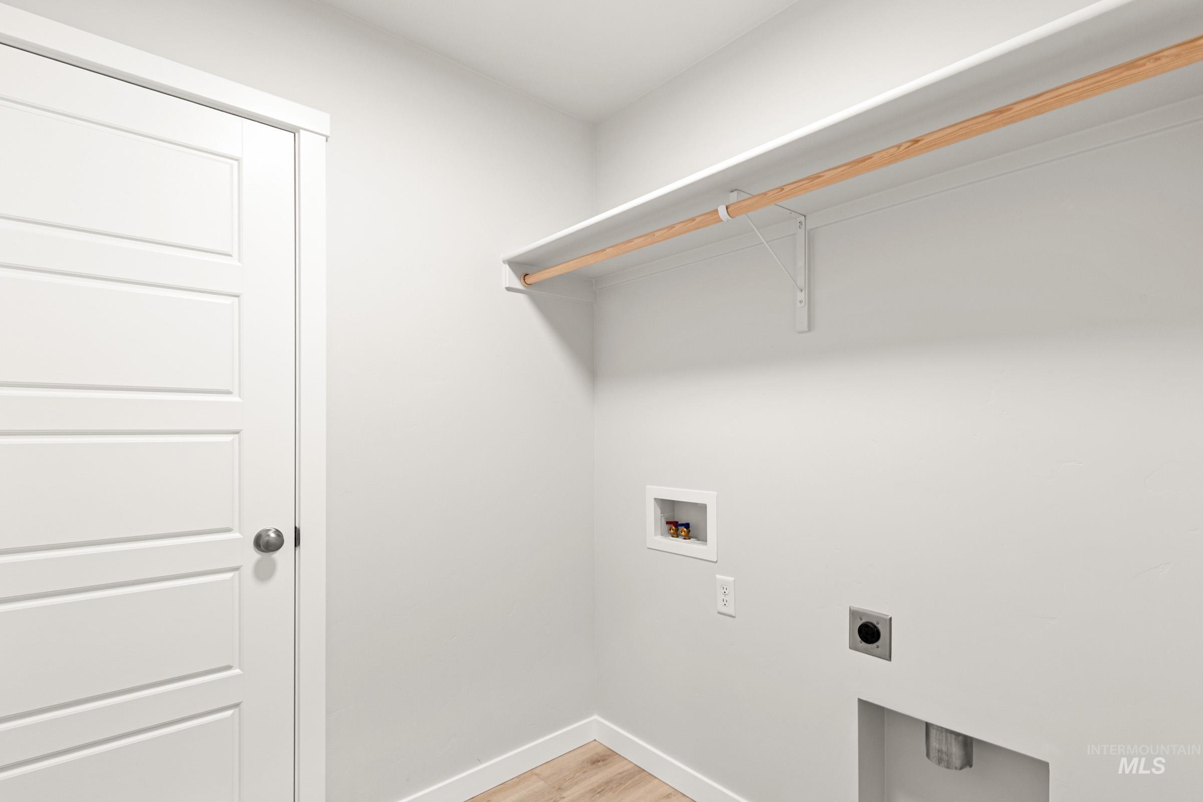 10818 Rutland Street Caldwell, ID 83605 - Photo 16 of 22 Laundry area with light wood-style floors, electric dryer hookup, and hookup for a washing machine
