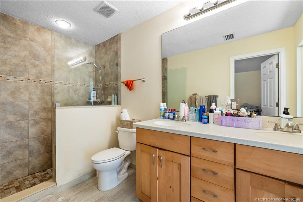 15848 129th Terrace North Jupiter, FL 33478 - Photo 28 of 52 a bathroom with a toilet sink vanity and mirror